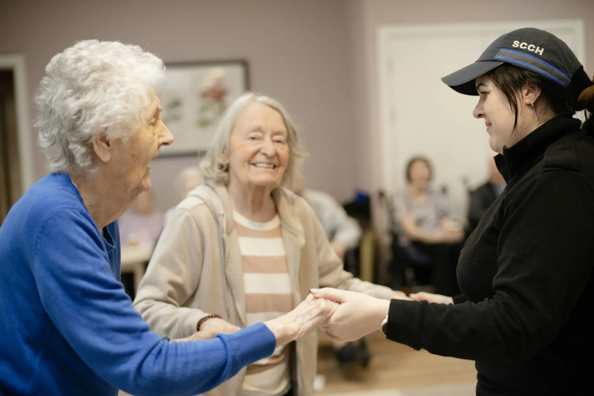 Older women holding hands with a younger woman