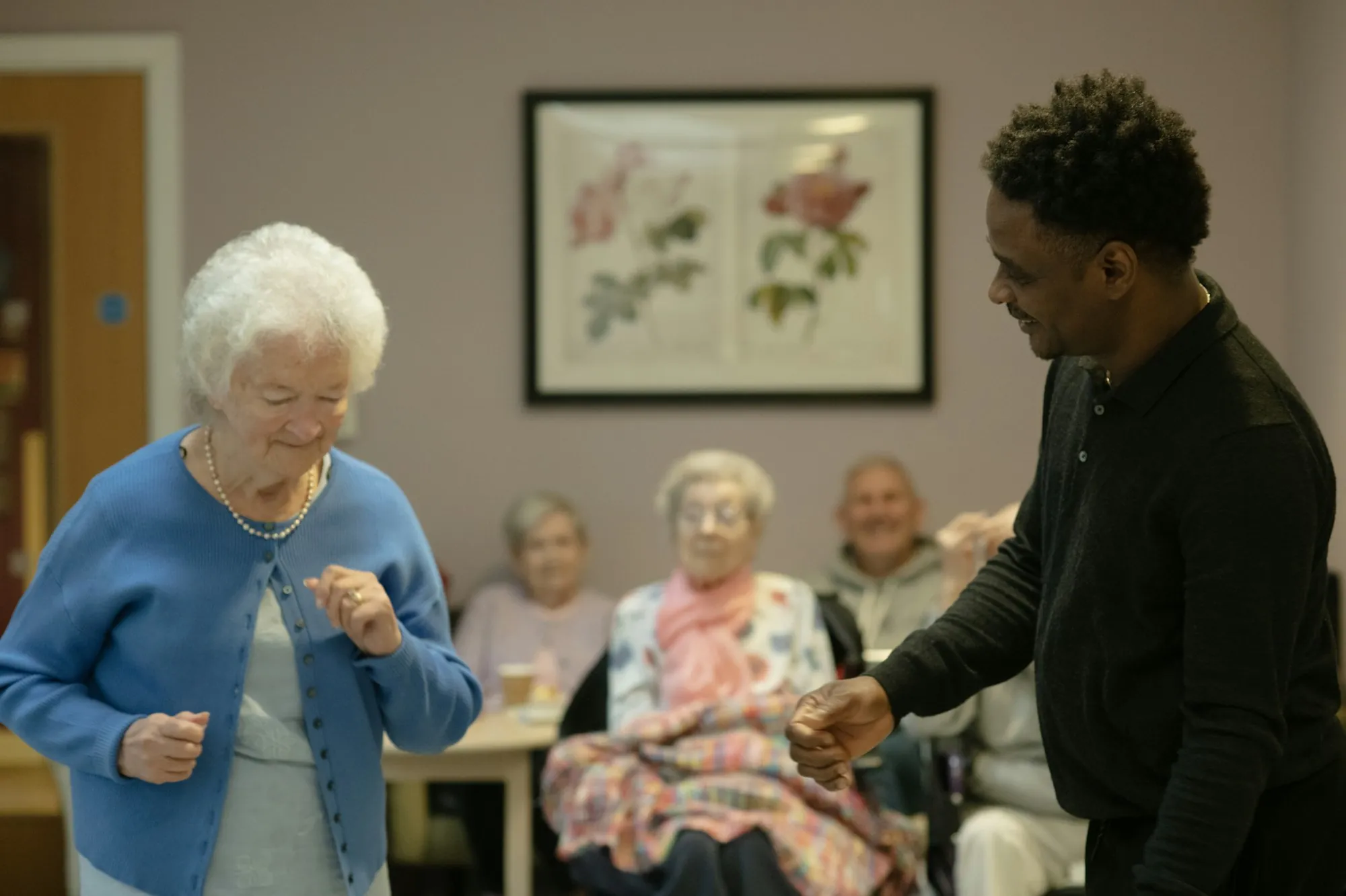 An older woman with a helper in her own room