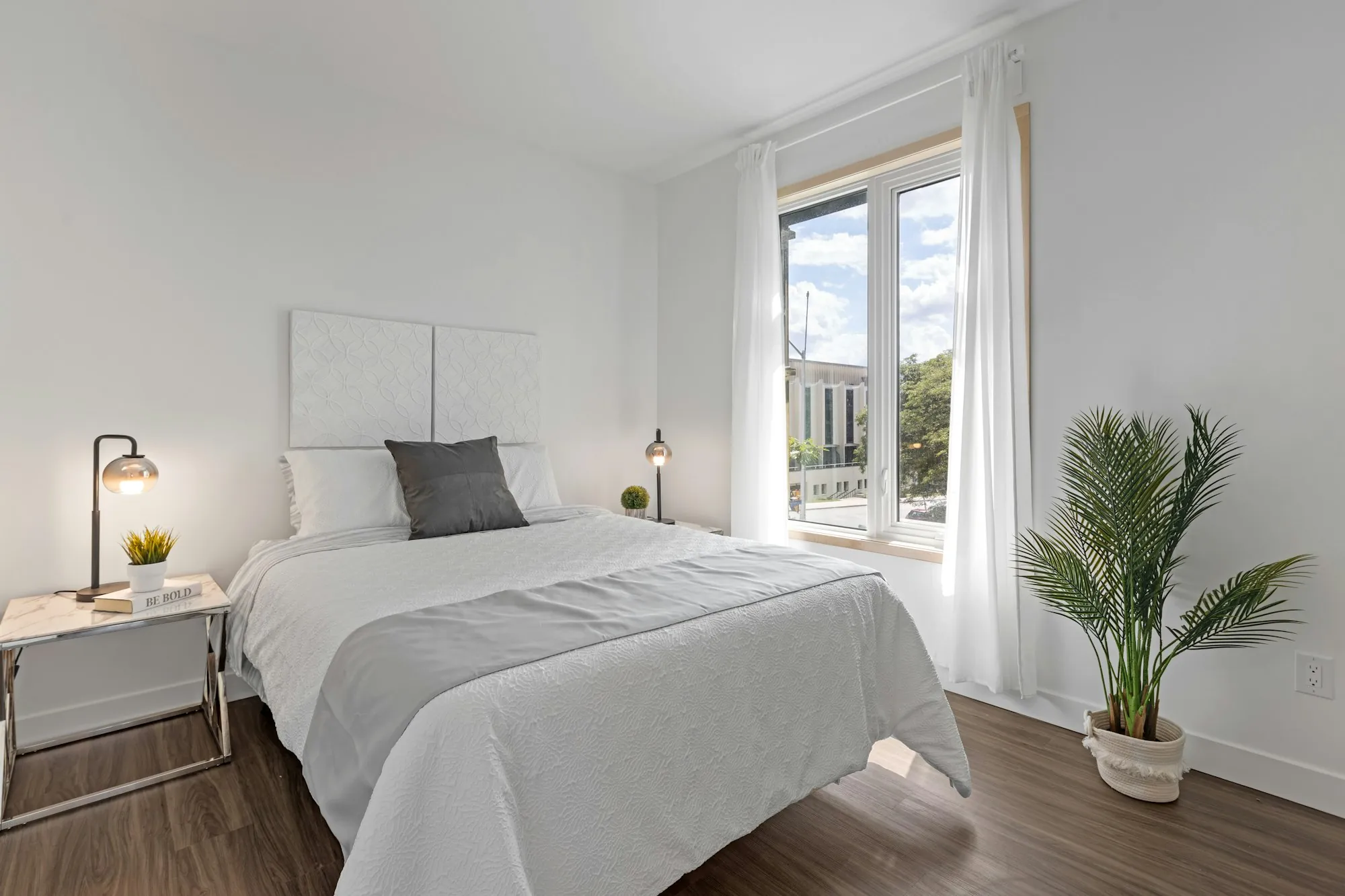 White bed linen beside a bright window