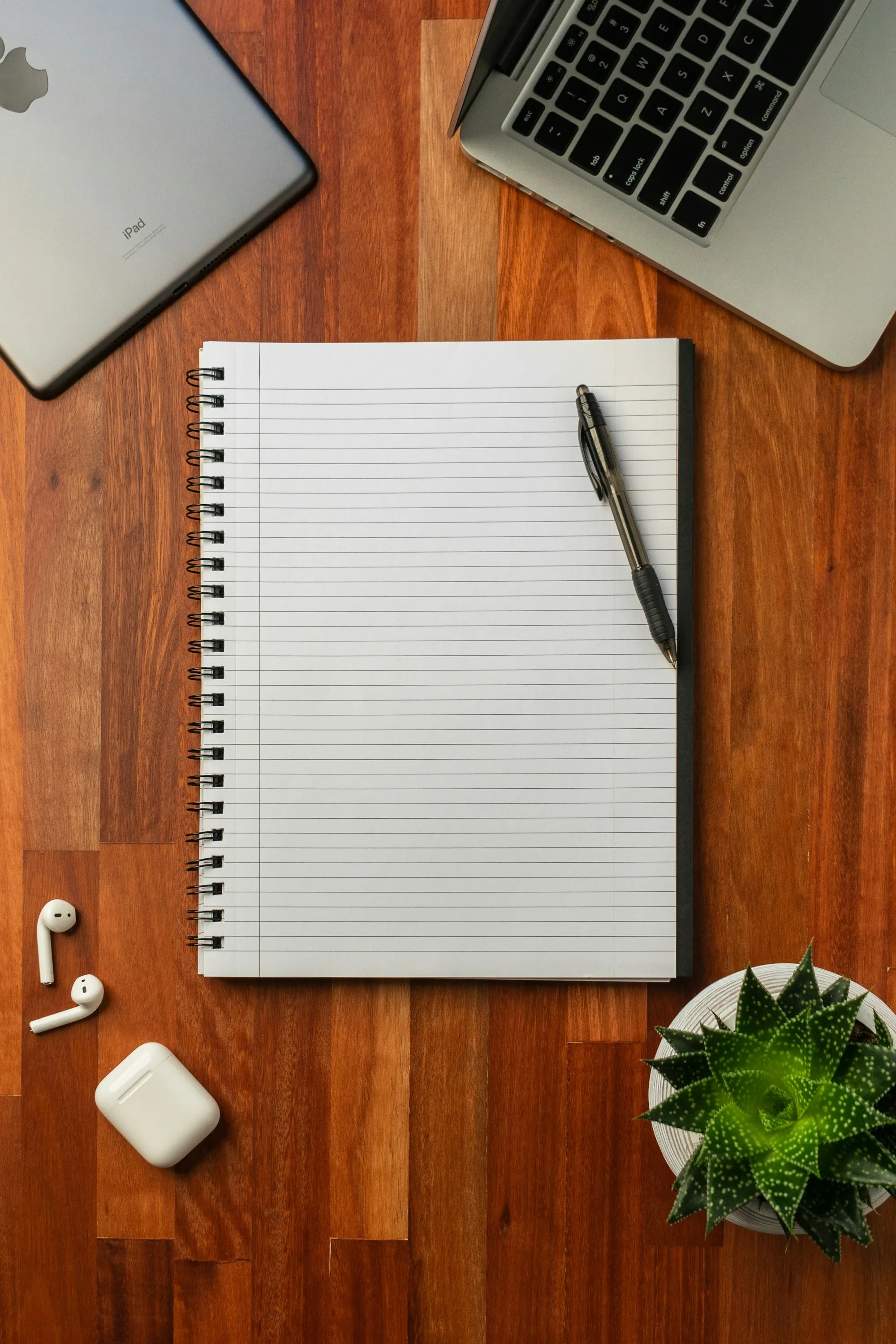A black pen resting on a white notebook